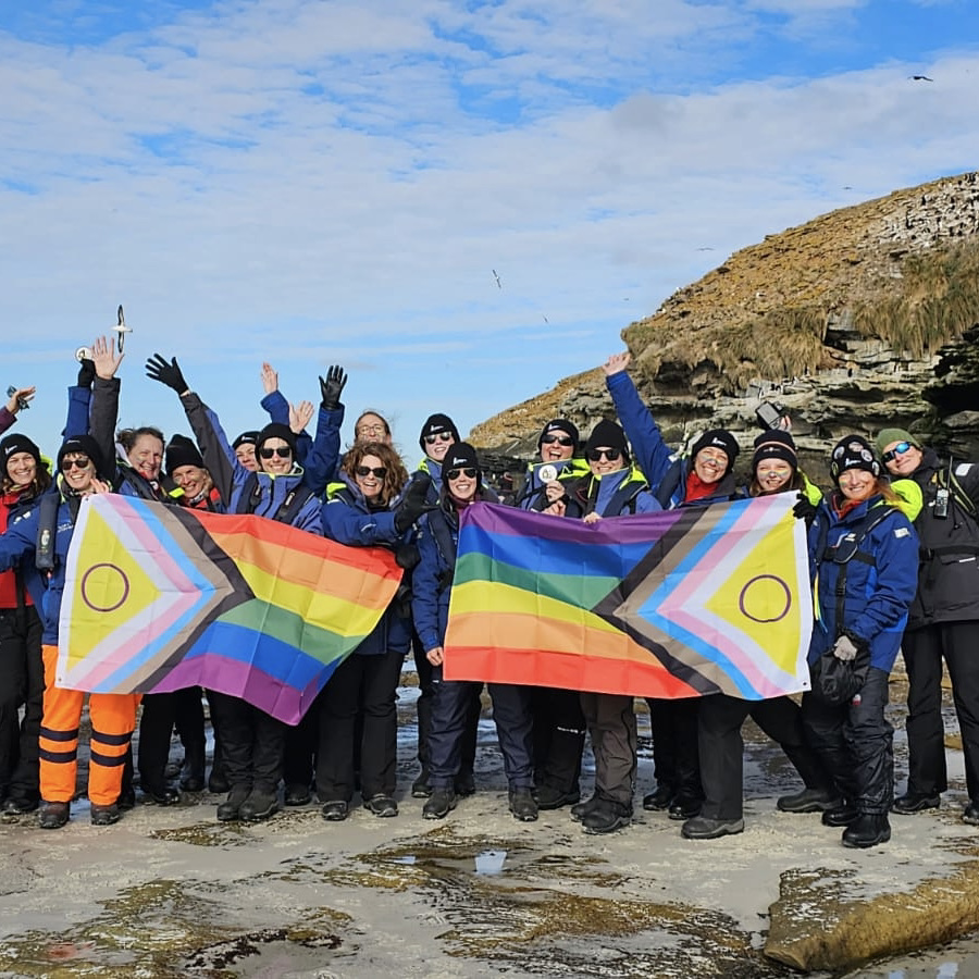 Homeward Bound participants on the beach with pride flags